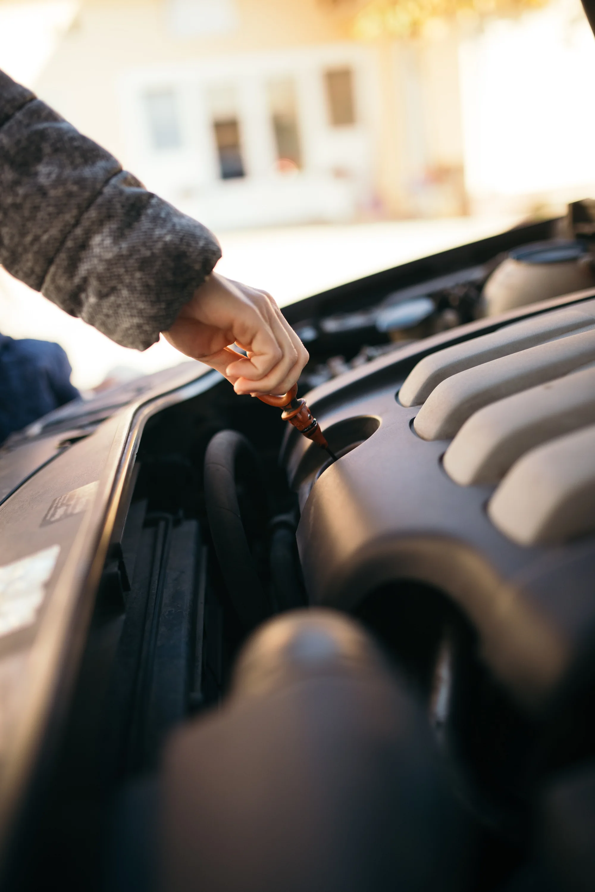Checking engine oil with a dipstick during routine vehicle maintenance
