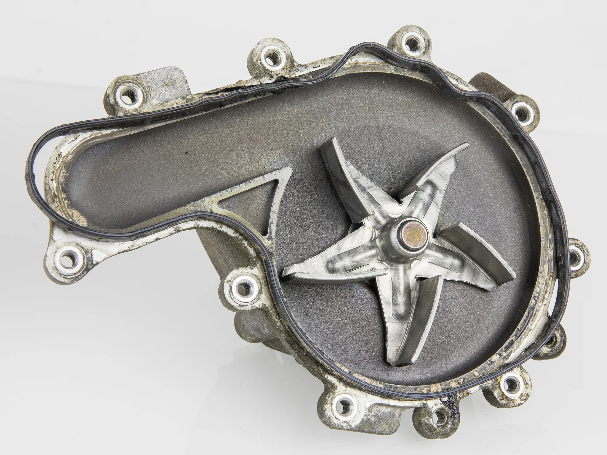 Opened automotive coolant pump showing the metal impeller