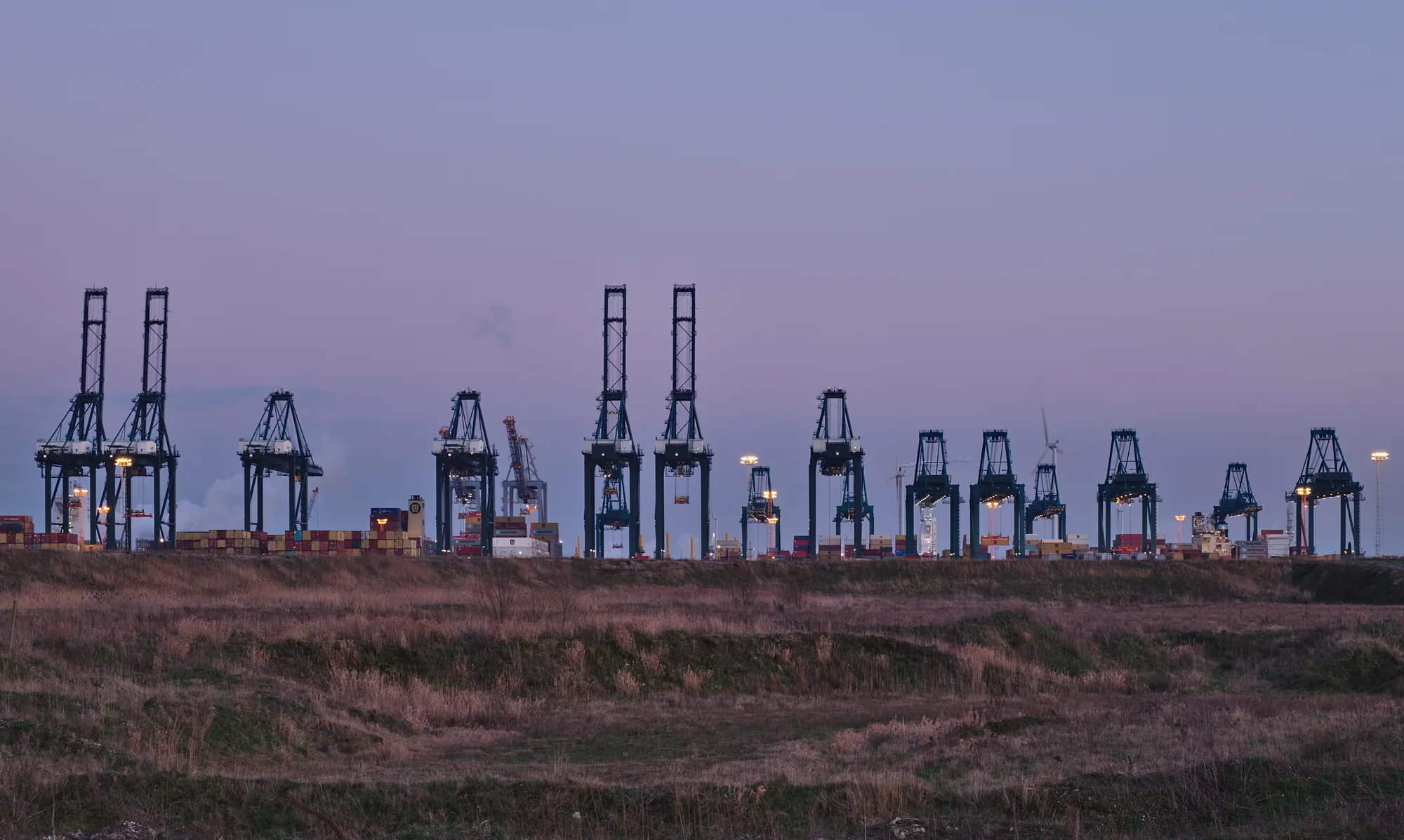 Container cranes at a commercial freight terminal at dusk